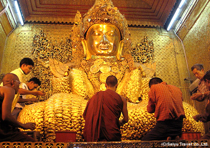 マハムニパゴダの仏像に金箔を寄進する人