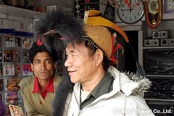 鳥の羽やくちばしで装飾の施された竹の帽子を被るニシ族の男性
