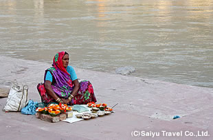 ガンジスのほとりで夕方のプージャに使う花を売る女性。